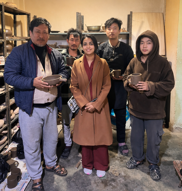 Drishty with the Longpi artisans holding their pottery